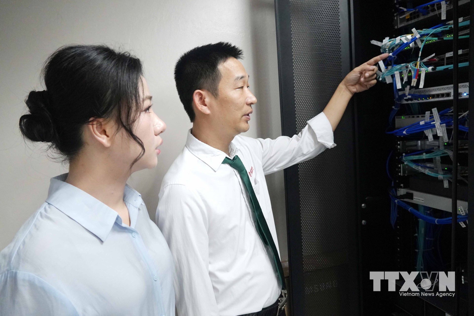 Phó Chủ tịch HĐQT Tổng Công ty Cổ phần Hợp Lực, Giám đốc điều hành Hệ thống y tế Hợp Lực Nguyễn Bảo Uyên (trái) kiểm tra phòng máy chủ - "bộ não" của bệnh viện. Ảnh: Việt Hoàng/TTXVN)